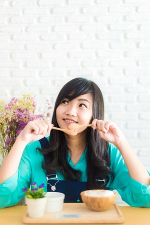 Happy Asian girl with ice cream look joyful and cheerful in coffee shopの写真素材
