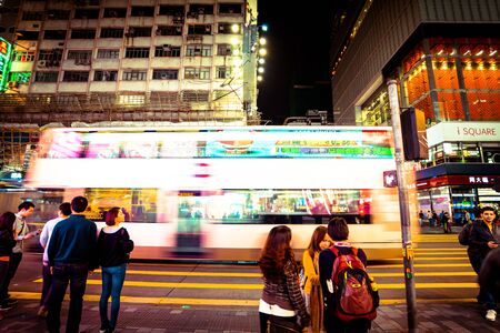 HONG KONG, CHINA - DECEMBER 4: Street view with traffic and shops at night on December 4, 2014 in Hong Kong, China. With 7M population and land mass of 1104 sq km, it is one of the most dense areas in the world.のeditorial素材
