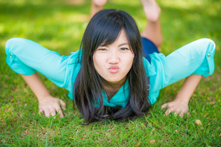 beautiful asian girl  lying down on green grass. Beautiful relaxing lying in the gardenの写真素材