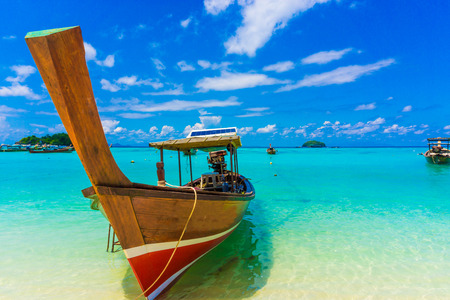 Wood boat and islands in andaman sea against blue sky at Lipe, Satun, Thailandの写真素材