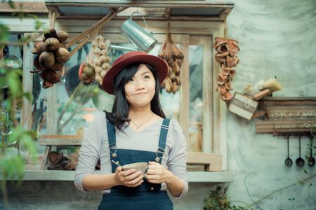 Asian beautiful cute girl in the cafe garden with coffee smiling, Vintage art toneの写真素材