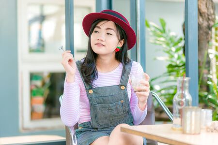 Beautiful cute girl in the cafe hold coffee mug, Happy young woman drinking coffeeの写真素材