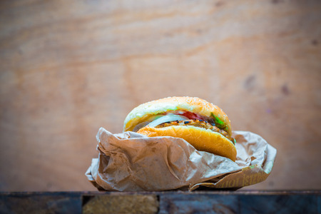 Delicious cheeseburger on brown paper and wooden tabletop with copyspaceの写真素材