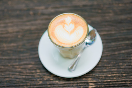 Coffee cup and flower figure on old wooden background take from above