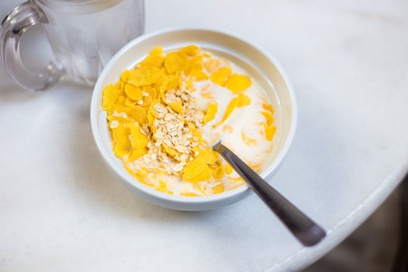 White bowl with breakfast cereal on table, Breakfast cereals with milkの写真素材