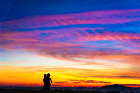 Silhouettes of a couple at beach in sunsetの写真素材