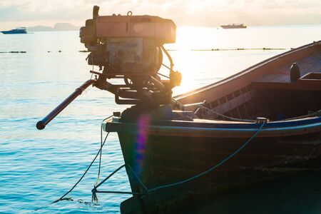 Wooden longtail boat on the beach at sunrise morning timeの写真素材