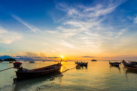 Wooden longtail boat on the beach at sunrise morning timeの写真素材