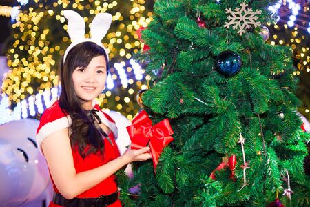 Asian women  wearing santa claus clothes with tree, christmas and celebrationの写真素材