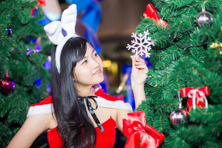 Asian women  wearing santa claus clothes with tree, christmas and celebrationの写真素材
