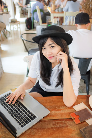 Woman using laptop and mobile phone in coffee shop. business concept.の写真素材