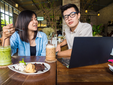 Asian businessman and woman meeting with laptop at coffee shopの写真素材