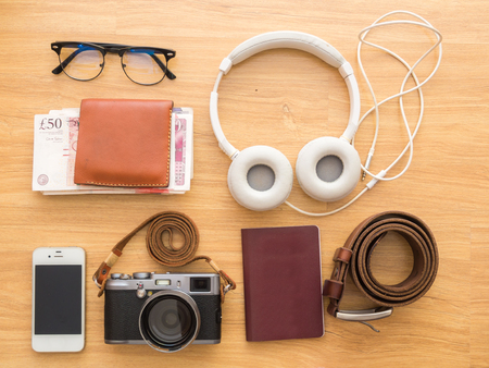 Travel and vacation concept on wood background with digital camera, cellphone, money, passportの写真素材