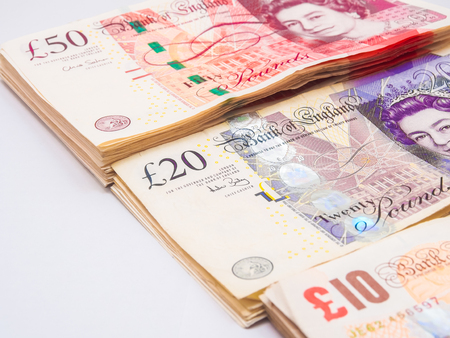 Bundle of pound currency on white, business finance making money concept.