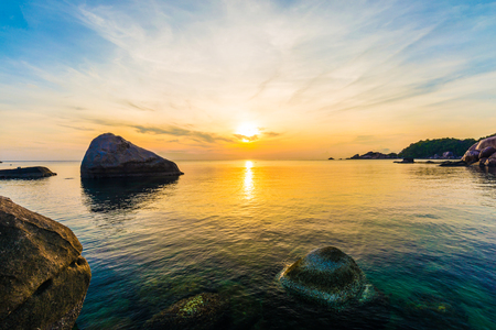 Sunrise on the coast of the Koh Tao at dawn with rocks in foregroundの写真素材