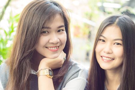 Two asian beautiful women Sitting Outside House, Close upの写真素材