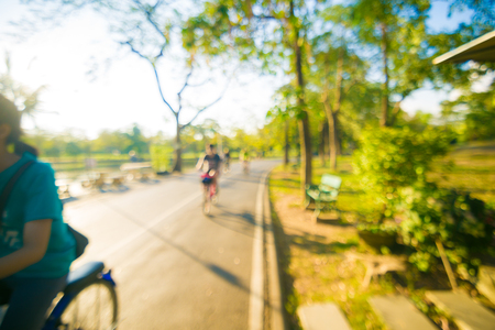 Blurred park people with bicycle and bokeh light, natural backgroundの写真素材