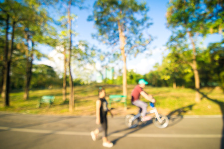 Blurred park people with bicycle and bokeh light, natural backgroundの写真素材