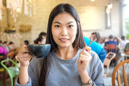Beautiful cute asian girl in the art cafe  with coffee smiling, Women Coffee Shopの写真素材