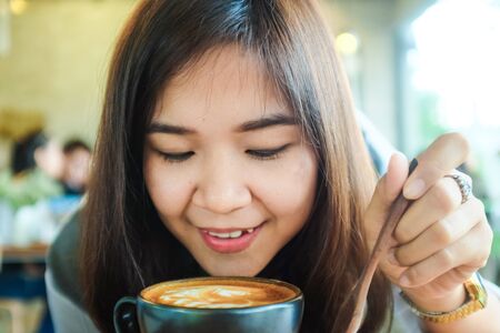Beautiful cute asian girl in the art cafe  with coffee smiling, Women Coffee Shopの写真素材