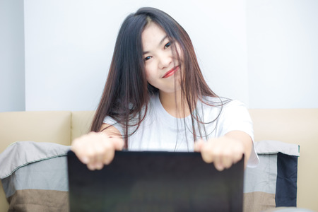 Asian black hair woman using laptop in bedroom, Beautuful women works on a laptopの写真素材