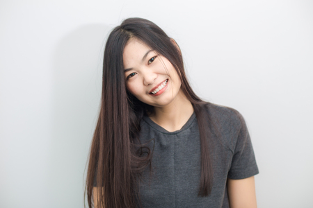 Bautiful asian girl smiling on gray background studio in living roomの写真素材