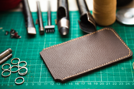 Tools for genuine leather crafting with cellphone cover case on work table