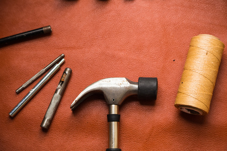 Leather crafting tools on work table. Genuine cow leather