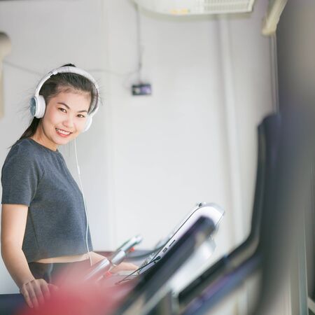 Beautiful young women exercising on a treadmill at the bright modern gymの写真素材