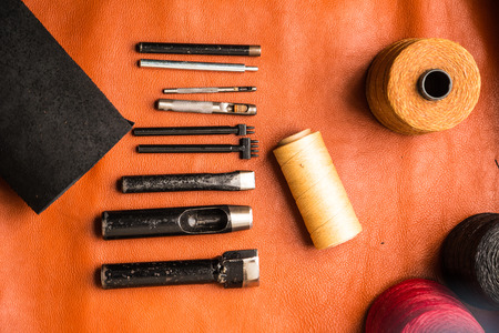 Leather crafting tools on work table with tan color genuine leatherの写真素材