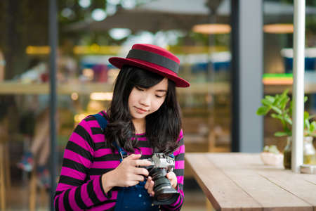 Lifestyle portrait of pretty young Photographer  woman having fun in coffee shop