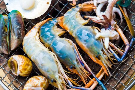 Grilled seafood shell and shrimps on the flaming grill.の写真素材