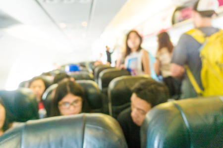Blurred background Interior of airplane with passengers on seats