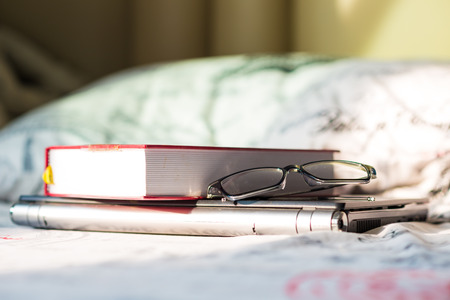 Books with a pair of glasses and computer laptop on bedroom, Technology learningの写真素材