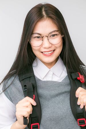 Portrait of beautiful Asian college student with notebook bag on white background