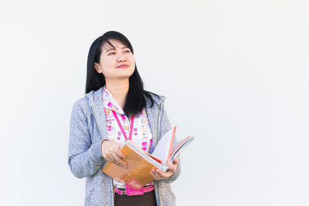 Portrait of asian beautiful woman wear office uniform reading a book outdoorの写真素材