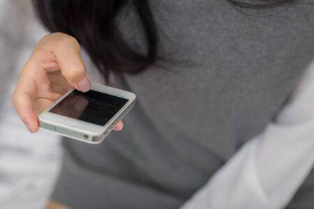 Cute asian woman using her cellphone in living room, Women with glasses