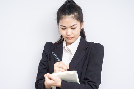 Portrait of happy asian smiling business woman with booklet wear blacksuit on white background