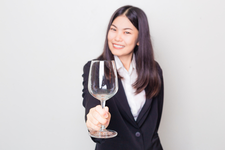 Beautiful asian business girl relax with glass of red wine for drinking alcohol on white backgroundの写真素材