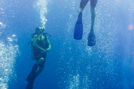 Underwater shoot of a divers trainnig openwater swimming in a blue clear waterの写真素材