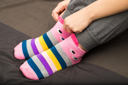 Slim leg asian woman in warm sweater and woolen socks on the bed winter conceptの写真素材