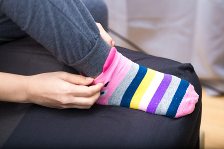 Slim leg asian woman in warm sweater and woolen socks on the bed winter conceptの写真素材