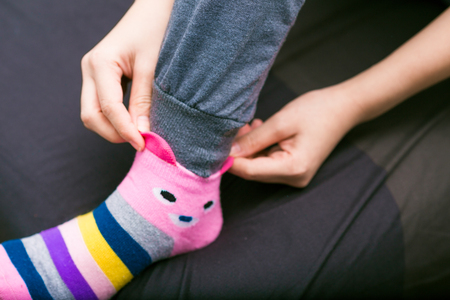 Slim leg asian woman in warm sweater and woolen socks on the bed winter conceptの写真素材