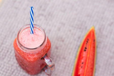Watermelon smoothy drink in glasses with slices of watermelon on rustic fabricの写真素材