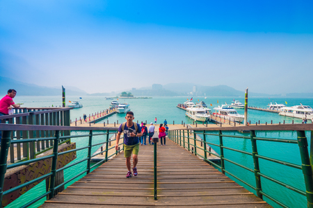 SUN MOON LAKE - MARCH 20: Tourist with boats parking at the pier on March 20, 2015 at Sun Moon Lake, Taiwan. Sun Moon Lake is the largest body of water in Taiwan as well as a tourist attraction.のeditorial素材