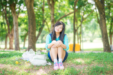 Women enjoying nature in green meadow with branch of tree, Freshness central parkの写真素材