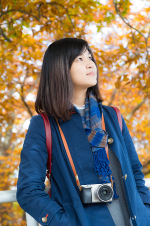 Travel photographer at work on autumn colourful tree leaves with cameraの写真素材
