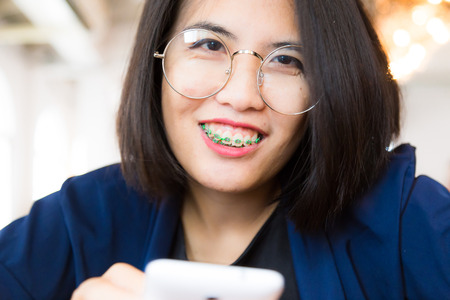 Smiling businesswoman with phone and laptop in cafe working for start up business, Technology and communication conceptの写真素材