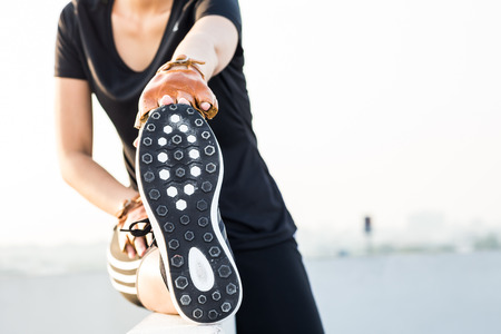 Happy asian young woman stretching before running city outdoors on the roof top of building
