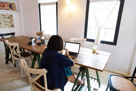 Happy Young Beautiful Asian Woman Using Laptop in art cafe, Indoorsの写真素材